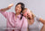 Woman squints in sunlight next to woman wearing pink Manta PRO sleep mask with overlay reading "True 100% blackout".