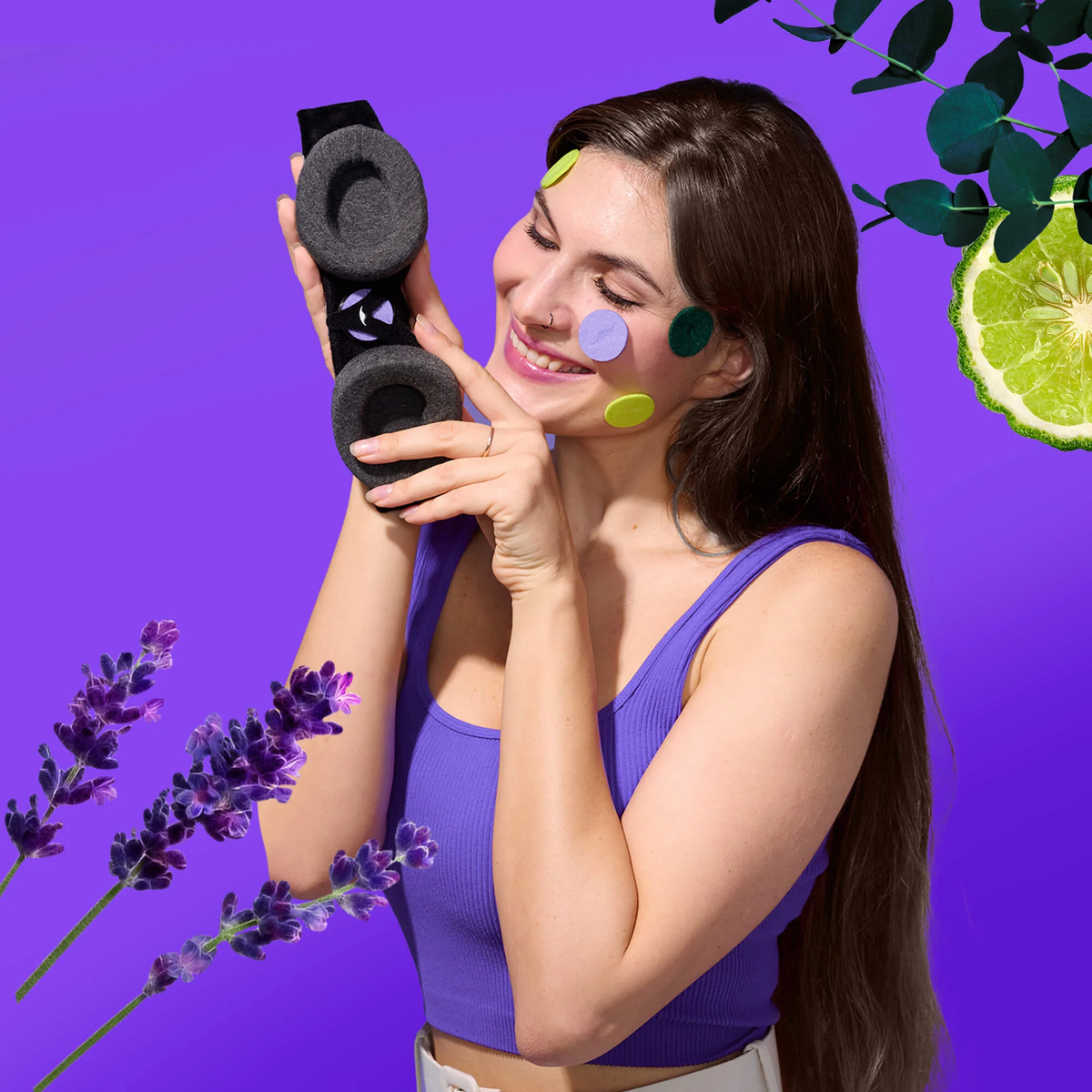 Woman holding a Manta sleep mask, with colorful aroma patches on her face, against a purple backdrop with lavender, eucalyptus and bergamot visuals.